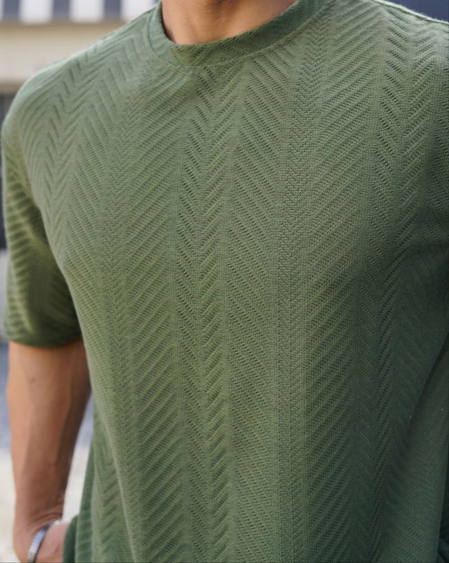 نمای نزدیک از تیشرت مردانه یقه گرد آستین کوتاه به رنگ سبز زیتونی با بافت برجسته طرح کاج برای فروش عمده