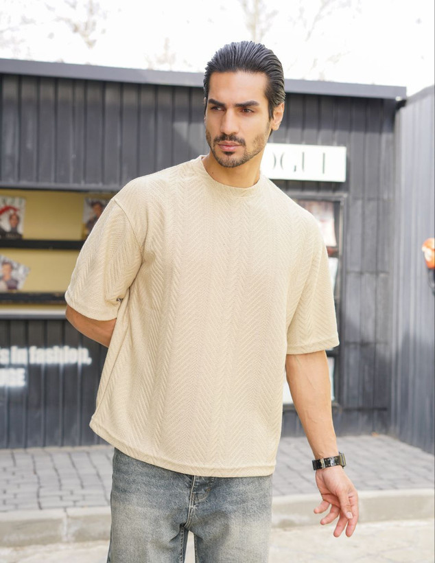 نمای نزدیک از تیشرت مردانه یقه گرد آستین کوتاه به رنگ کرم با بافت برجسته طرح کاج برای فروش عمده