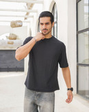 نمای نزدیک از تیشرت مردانه یقه گرد آستین کوتاه به رنگ مشکی با بافت برجسته طرح کاج برای فروش عمده